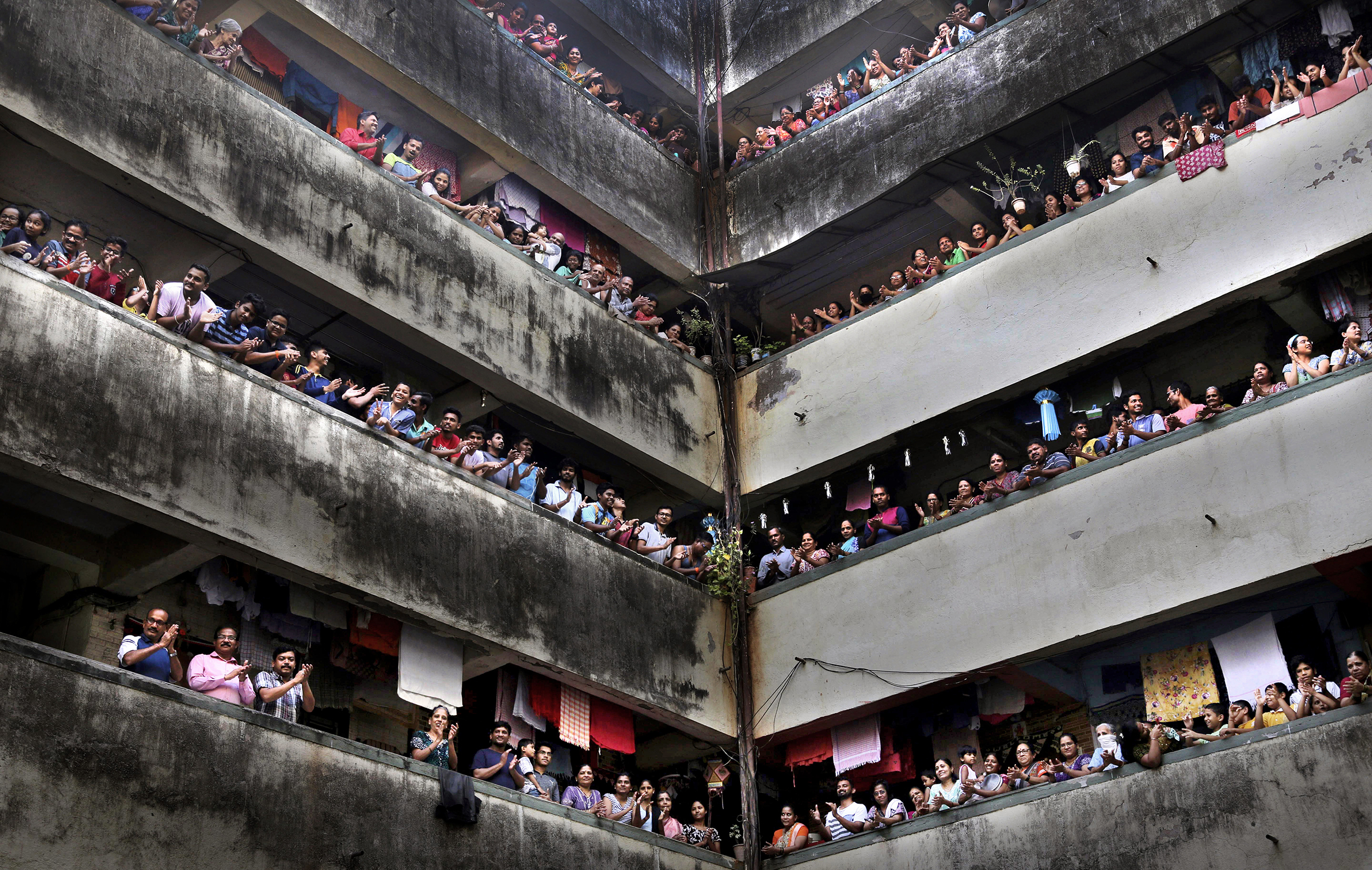 People clap from balconies in show of appreciation to health care workers at a chawl in Mumbai, India, on March 22, 2020.