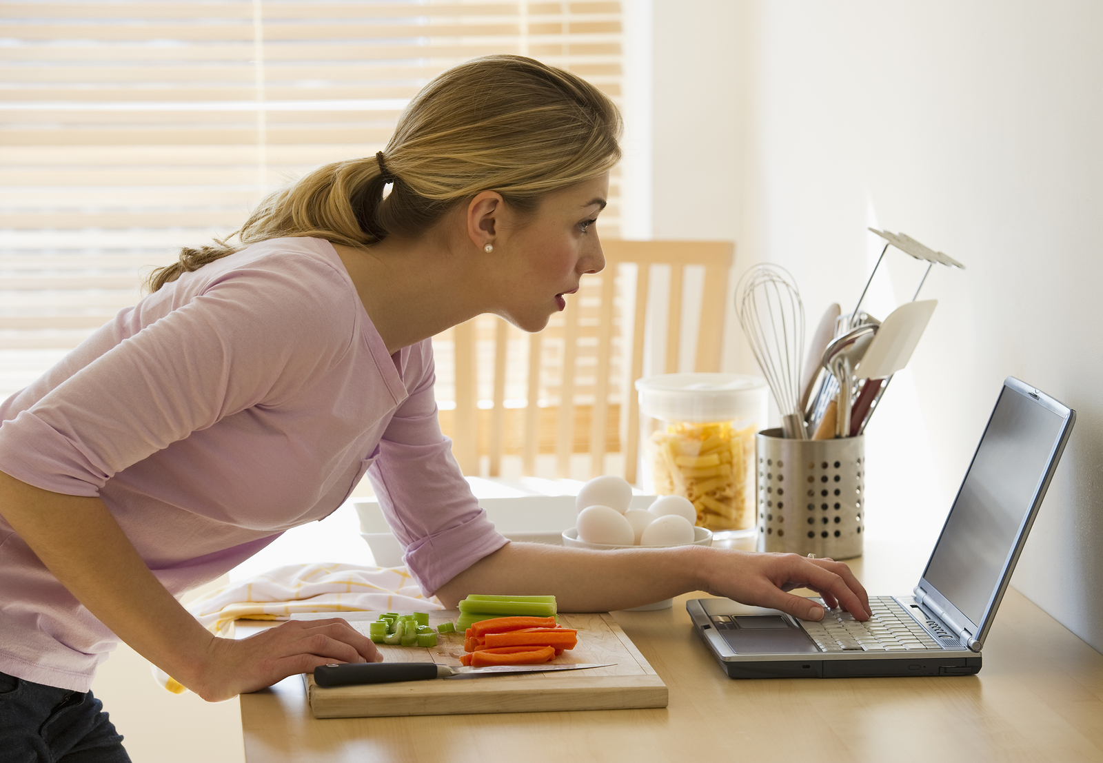 Где можно работать дома. Женщина на кухне за ноутбуком. Девушка за ноутбуком на кухне. Домохозяйка за компьютером. Женщина работает дома.